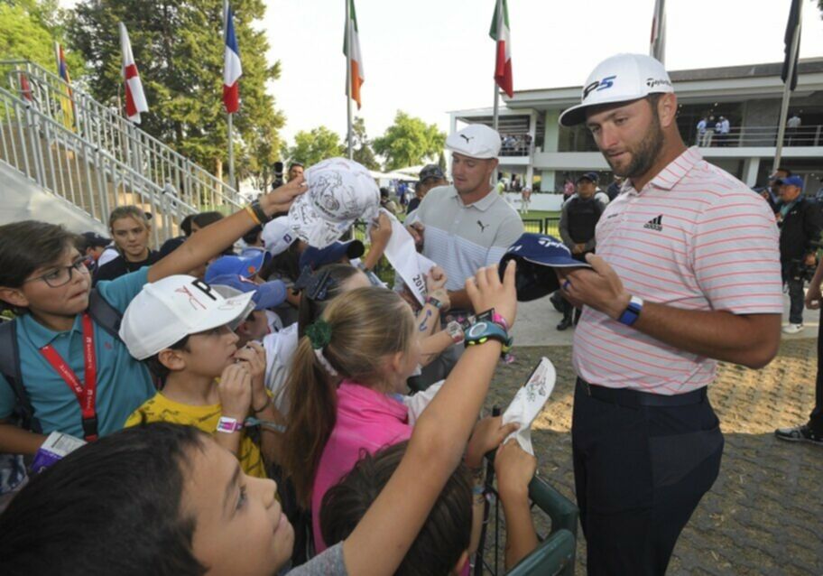 Jon Rahm and Bryson DeChambeau sign autographs