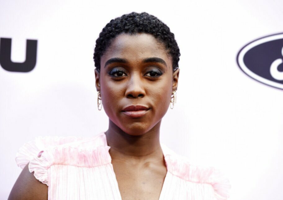 Lashana Lynch in white dress on red carpet