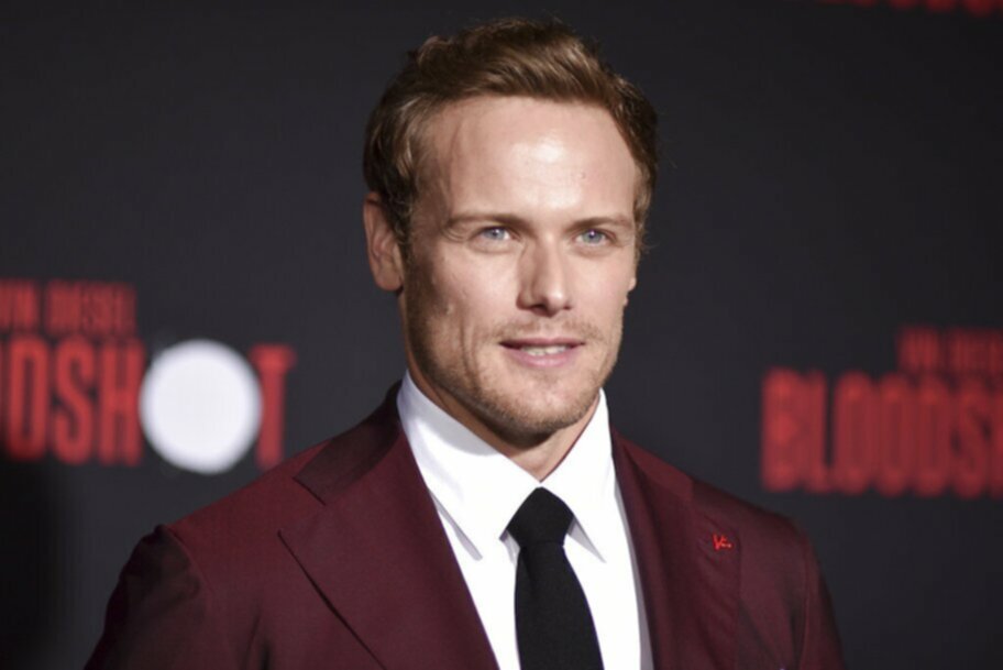 Sam Heughan in red jacket on red carpet