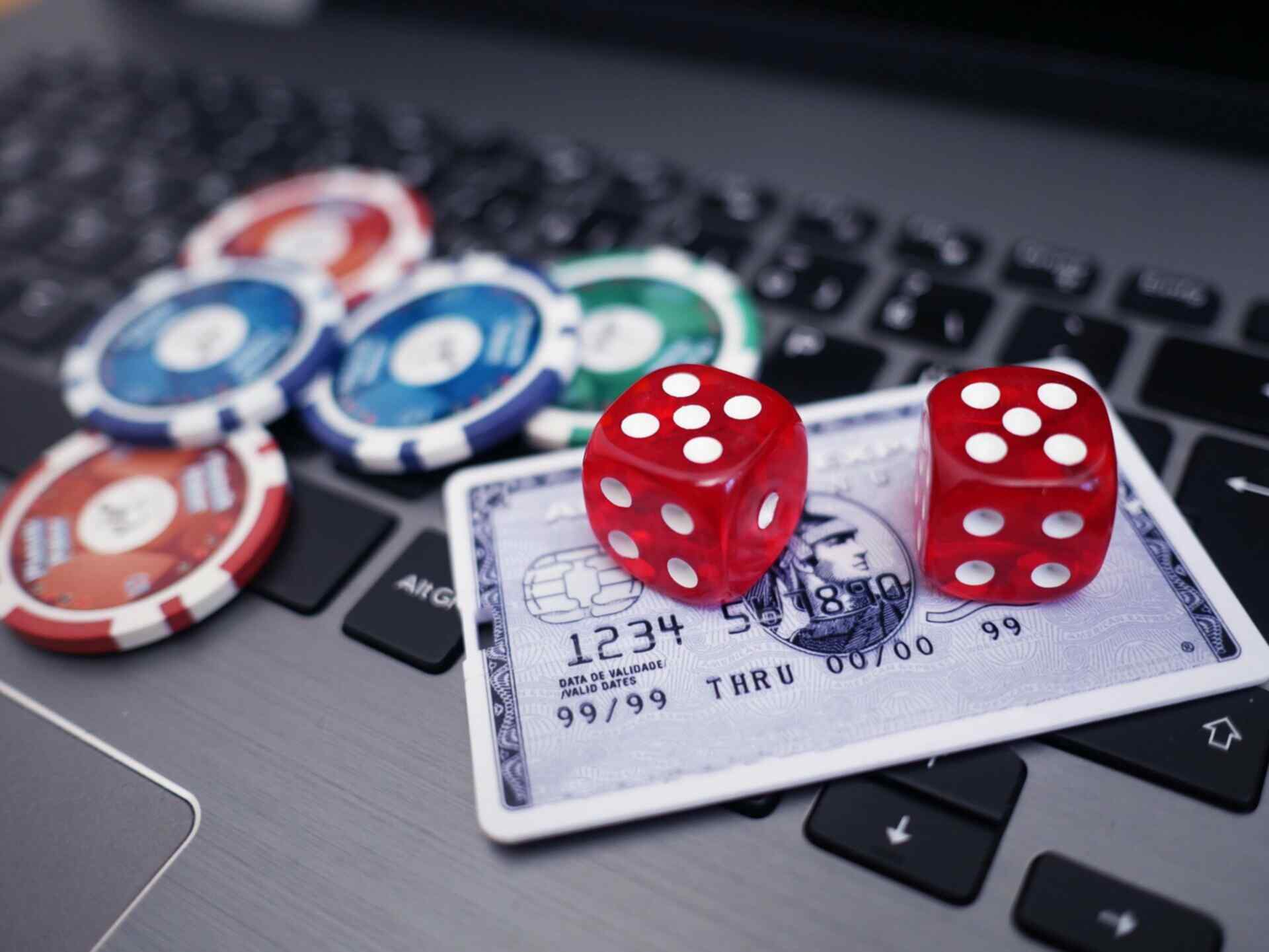 credit card, poker chips and playing cards on laptop