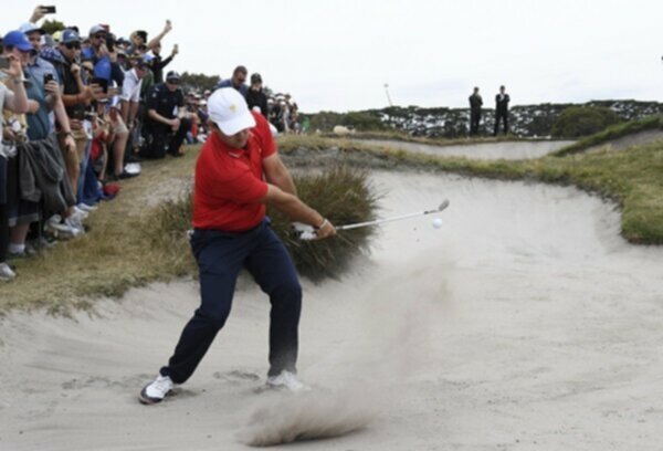 Patrick Reed hits a shot out of the bunker