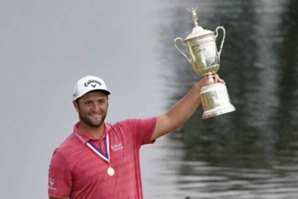 Jon Rahm holds up the US Open trophy