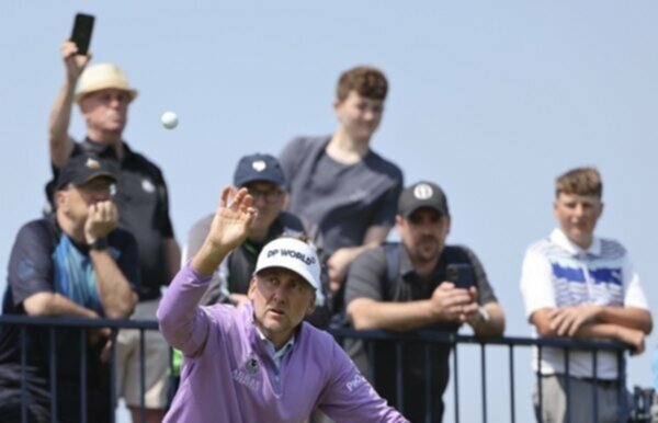 Ian Poulter catches a golf ball during a practice round at the British Open