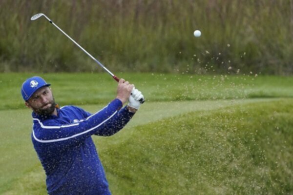 Jon Rahm hits a shot out of the bunker